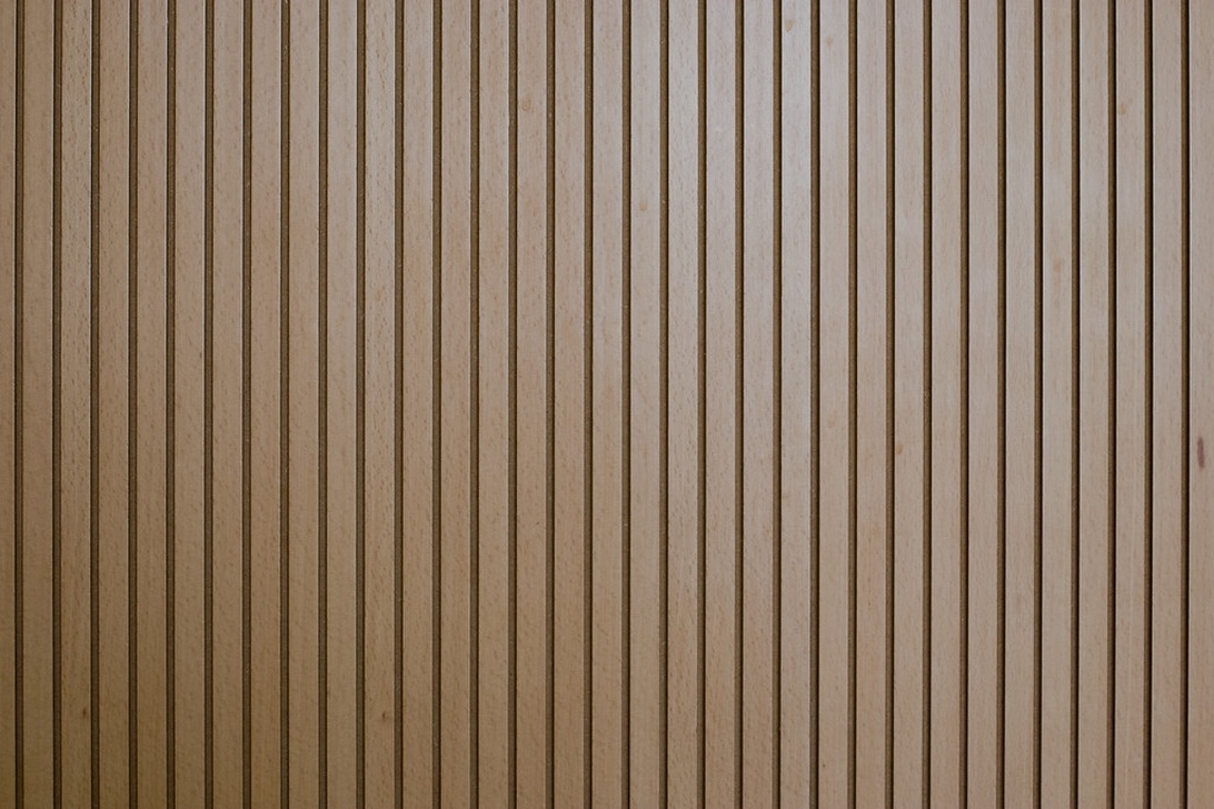 Närbild som visar den varma och texturerade ytan hos träribbor, en central design för moderna akustikpaneler.