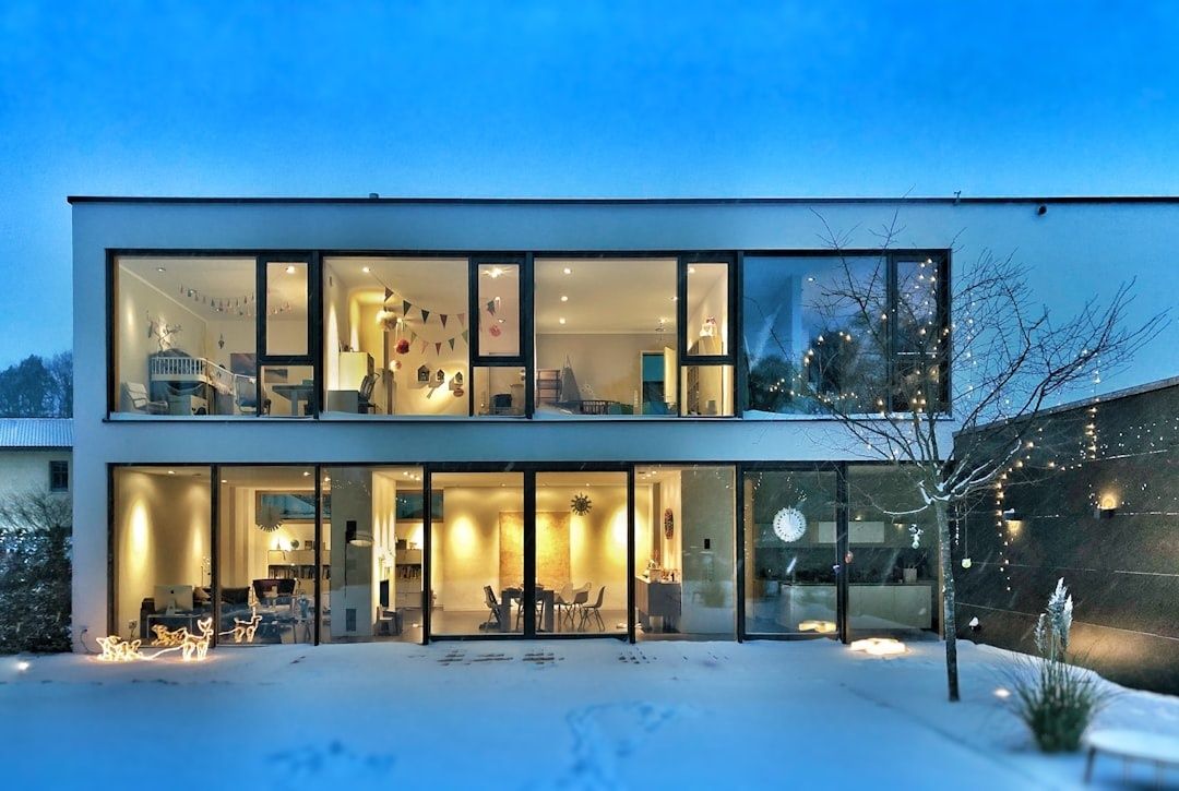 Modernt hus med stora energieffektiva fönster i vinterskymning